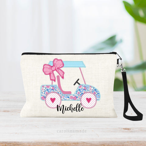 This beautiful linen zipper pouch with wristlet strap features a girly faux embroidery print with a golf cart and pink bow. It is personalized at the bottom with your name.