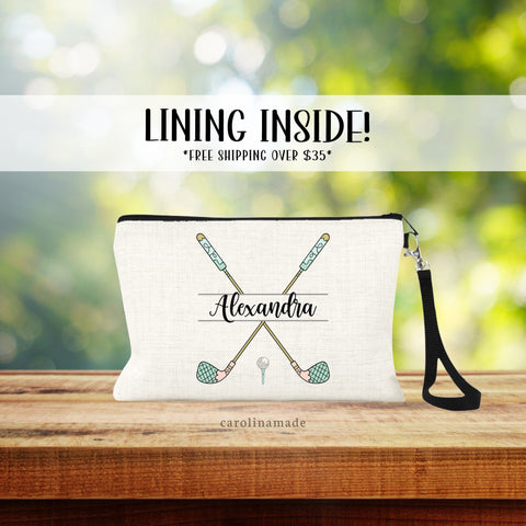 This linen zipper pouch features two golf clubs crossed each other with a name personalized in the center. Golf clubs are in a fun whimsical print. With golf ball and tee at the bottom.
